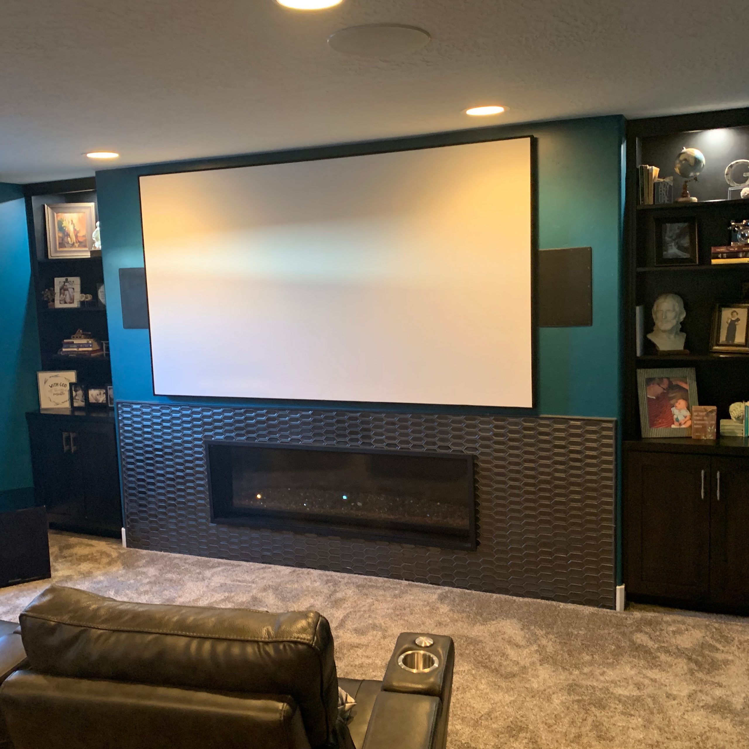 A comfortable home theater area showcasing a large screen and a fireplace, offering the ideal setting for entertainment and comfort.