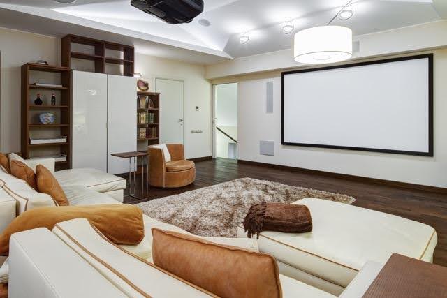 A cozy home theater room featuring a large screen for viewing movies and shows comfortably