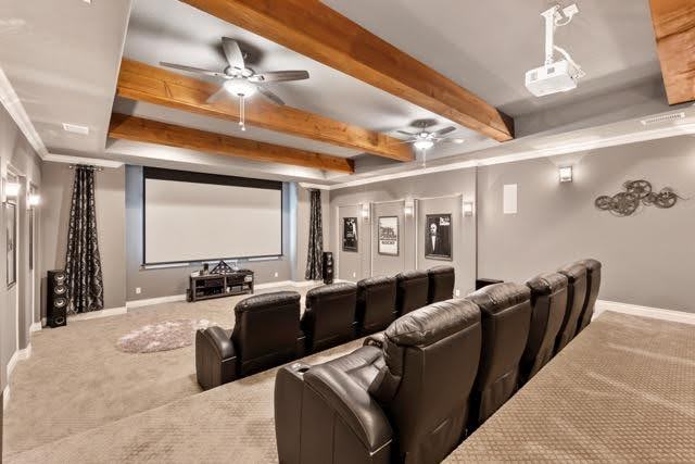 An interior view of a home theater with a spacious layout highlighted by a large screen and cozy seating arrangement