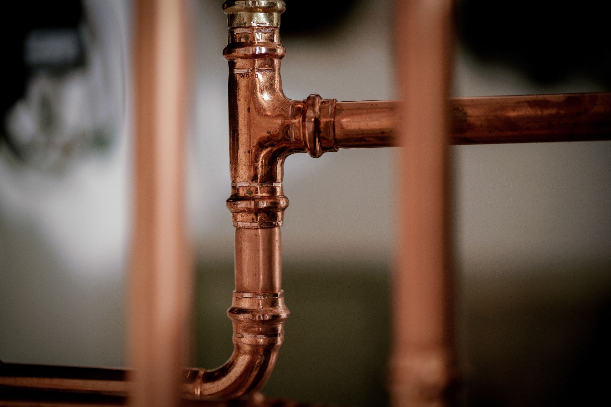 Close-up of polished copper plumbing pipes and T-joint fitting
