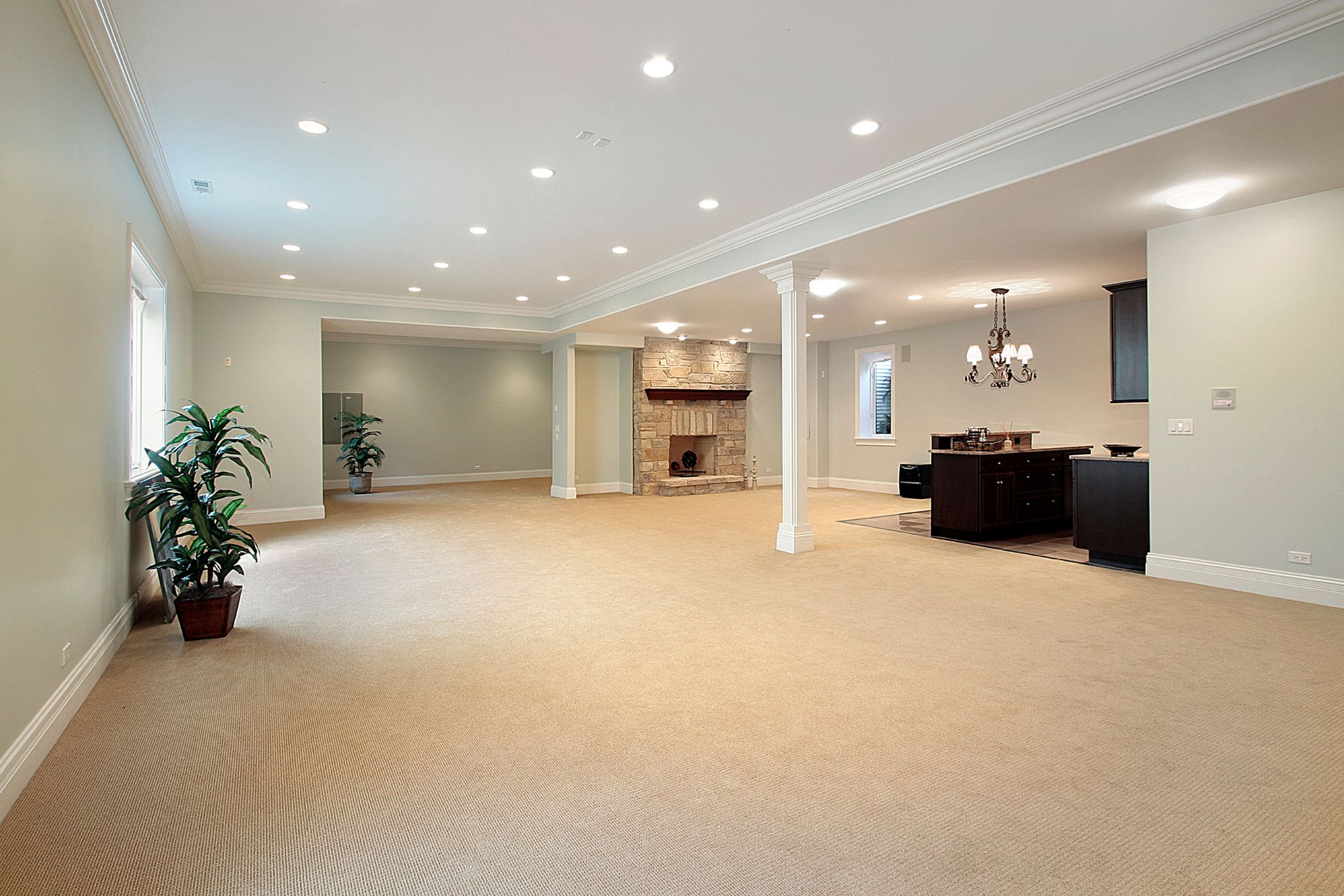 Spacious carpeted open basement with stone fireplace and wet bar