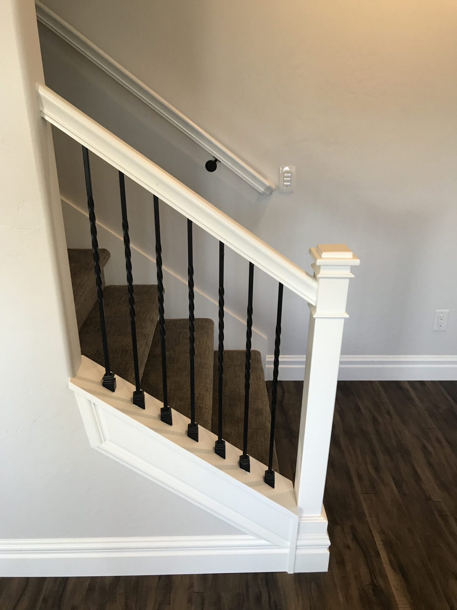 Staircase with white railings and handrail in Utah Basement Finishers