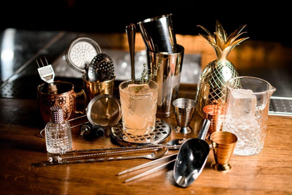 A vibrant bar scene featuring diverse cocktail ingredients and essential utensils for crafting drinks