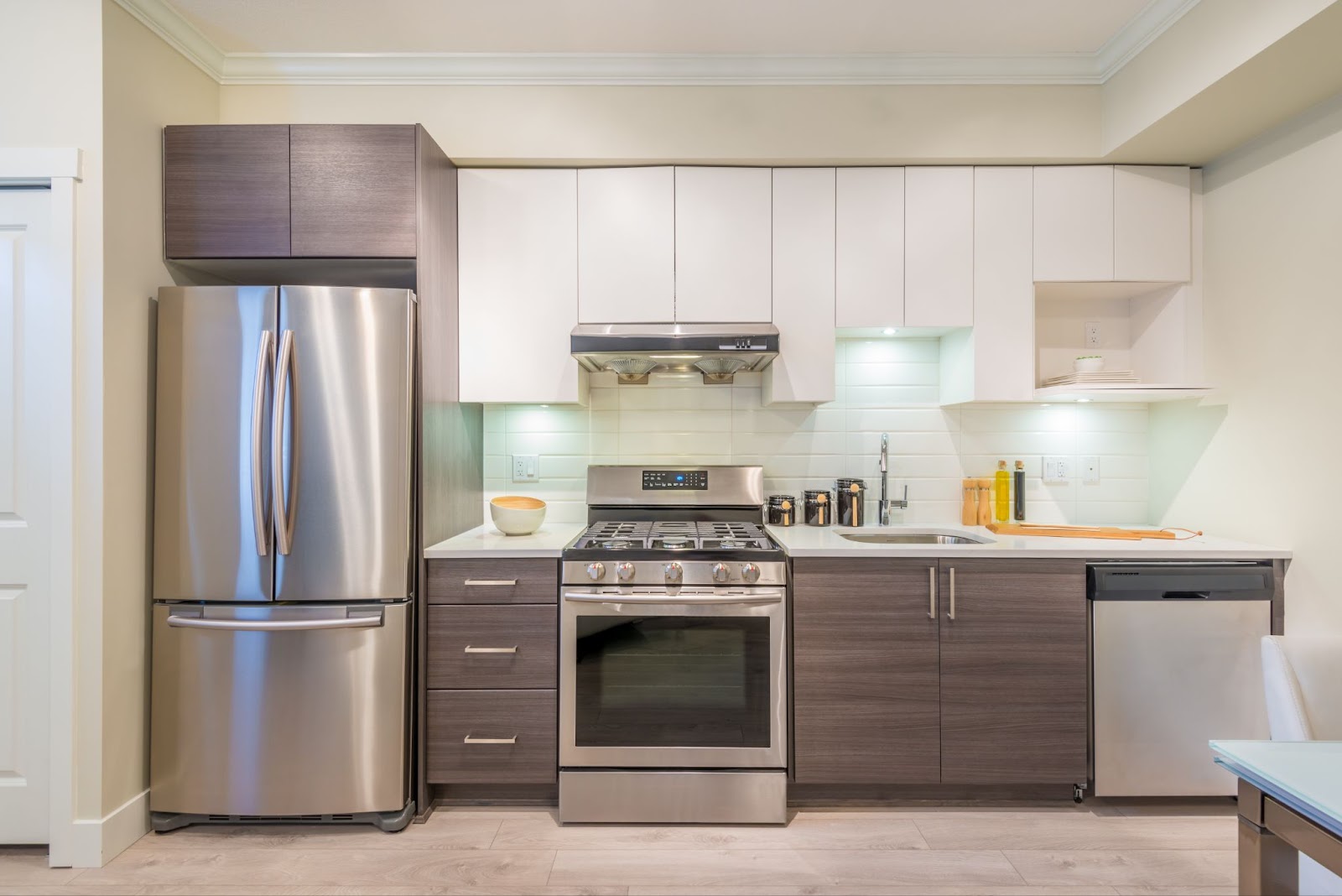 A stylish kitchen with stainless steel appliances and warm wooden floors for a contemporary look