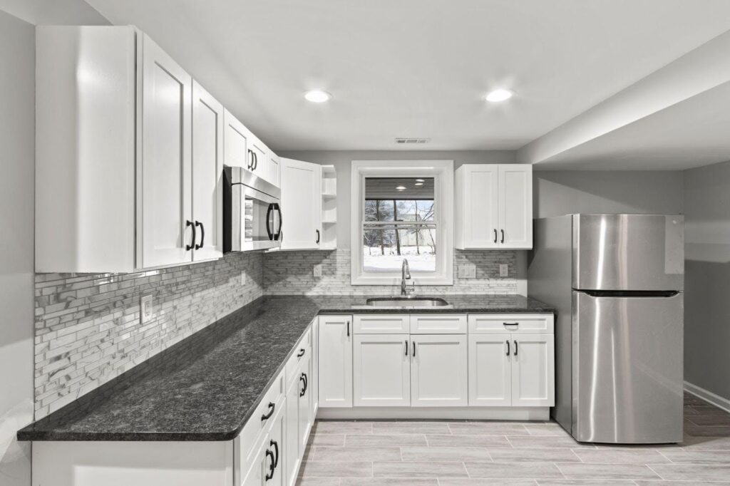 A modern kitchen featuring white cabinets and sleek stainless steel appliances