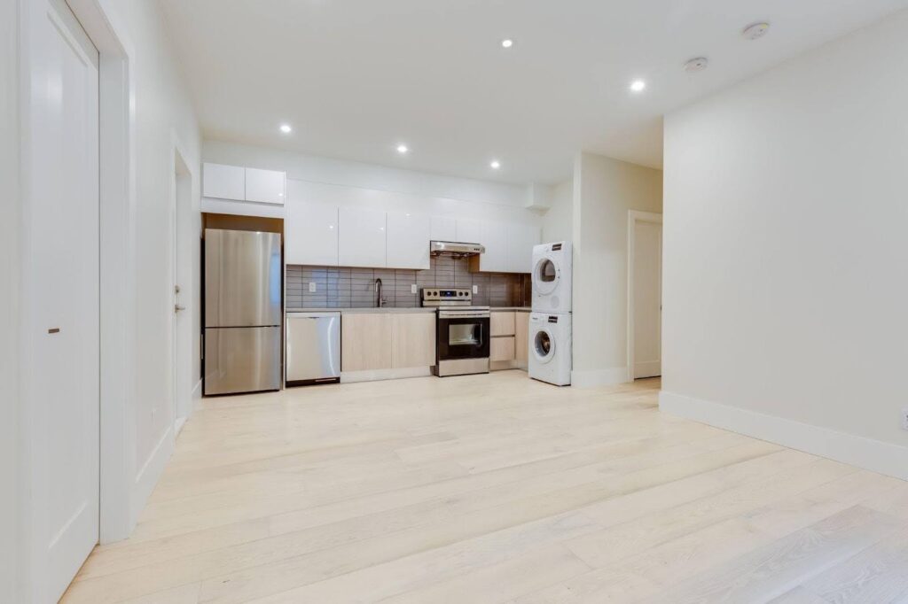 A tidy kitchen with crisp white walls and warm wooden floors exuding a fresh and welcoming feel