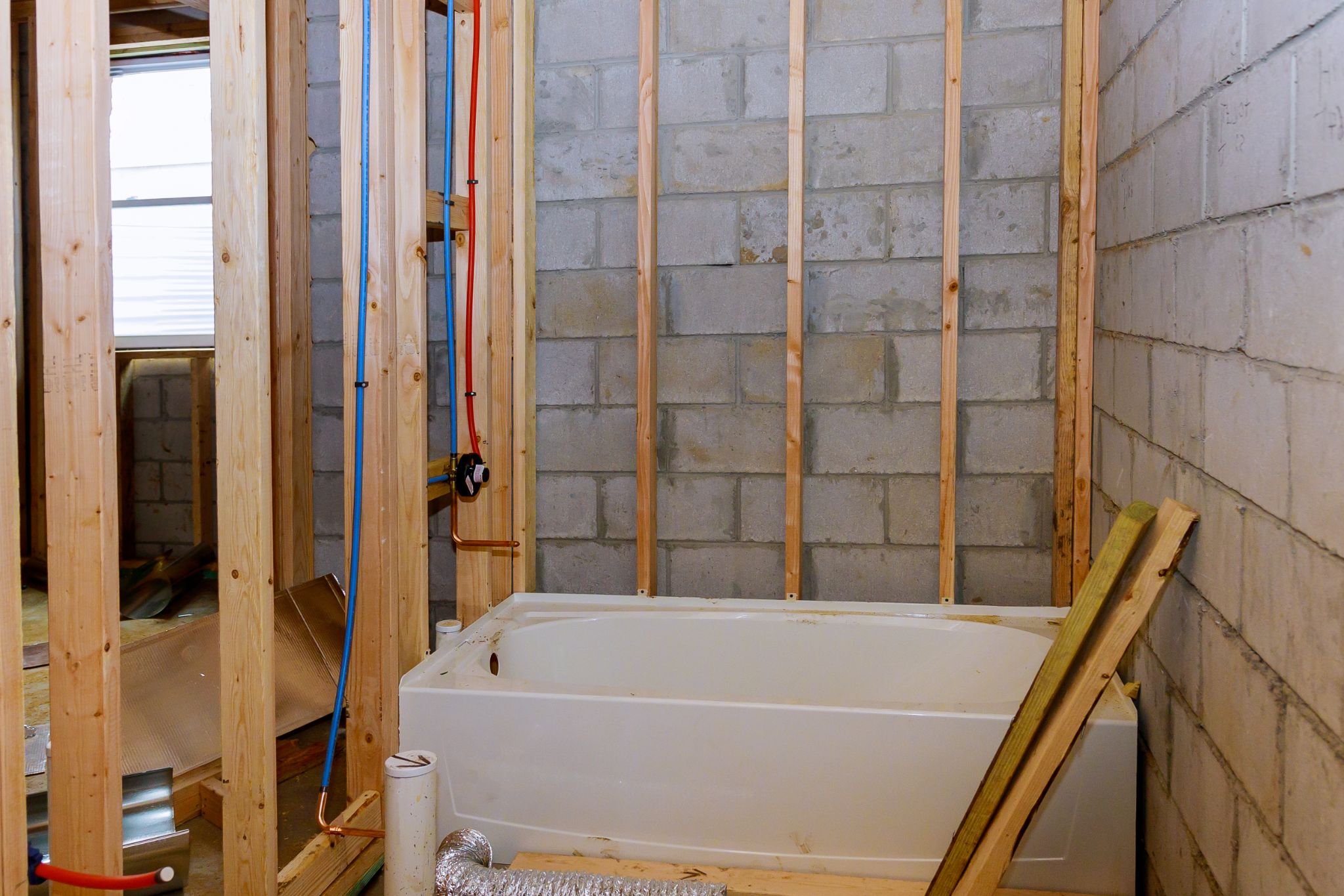 A bathtub installed during the rough-in plumbing stage of a bathroom construction or renovation project.