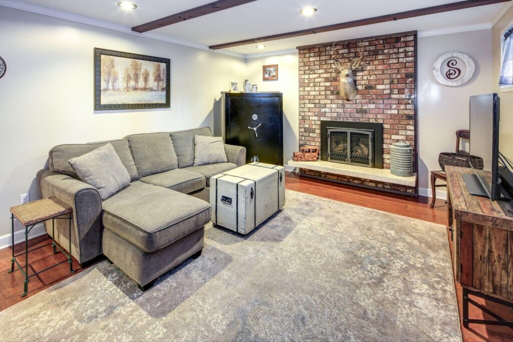 A stylish living room with a soft couch an inviting fireplace and a large television for entertainment