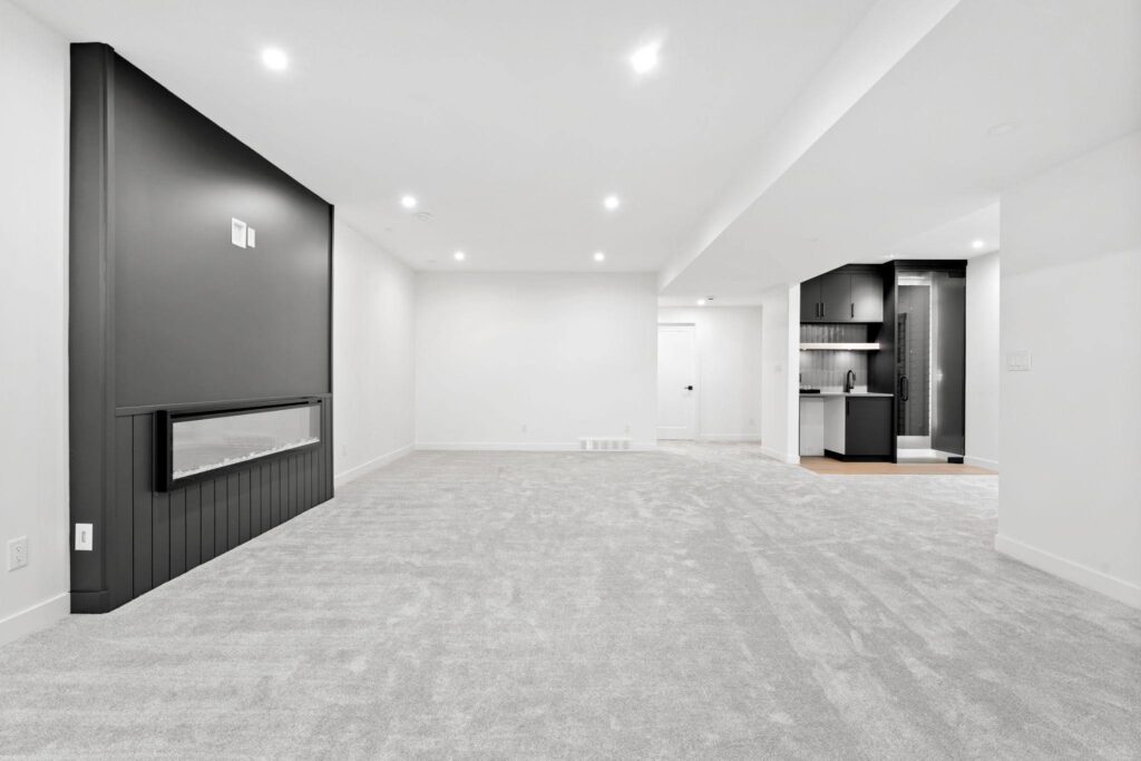 An empty clean room featuring a fireplace and a wall mounted television creating a modern and open atmosphere