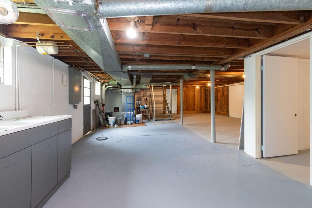 Interior view of a basement highlighting a compact kitchen and a bathroom designed for practical use